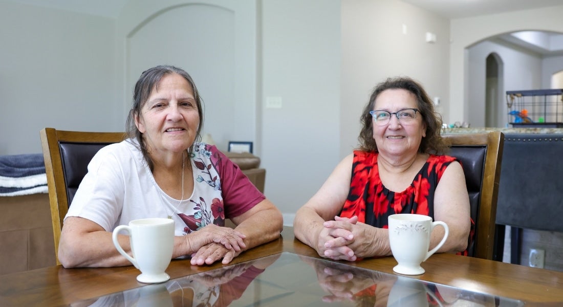 Mary Stierhoff and Carmen Alfaro sitting at a table